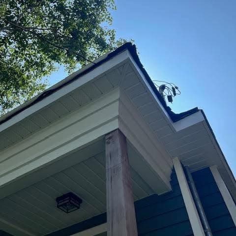 Porch corner with new white soffit and fascia against blue siding